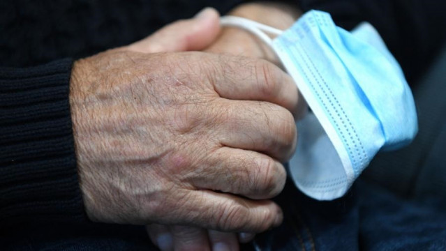 Archivo - Una persona mayor con una mascarilla