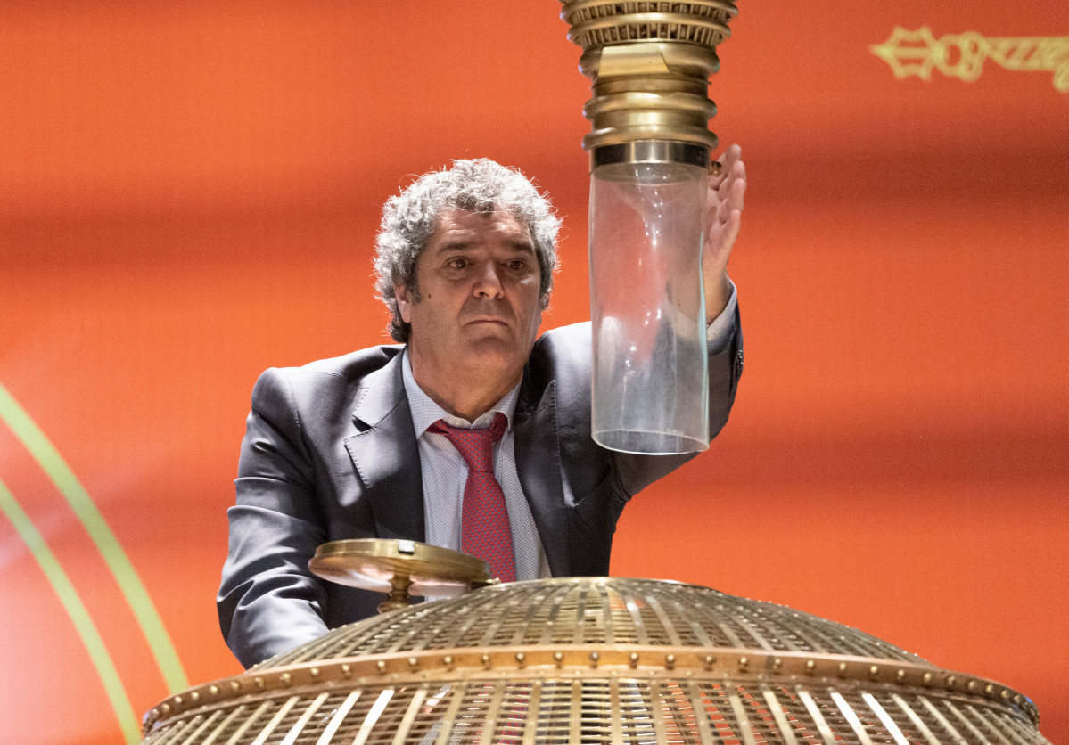 Un hombre prepara los bombos para dar comienzo al Sorteo Extraordinario de la Lotería de Navidad 2022, en el Teatro Real de Madrid.