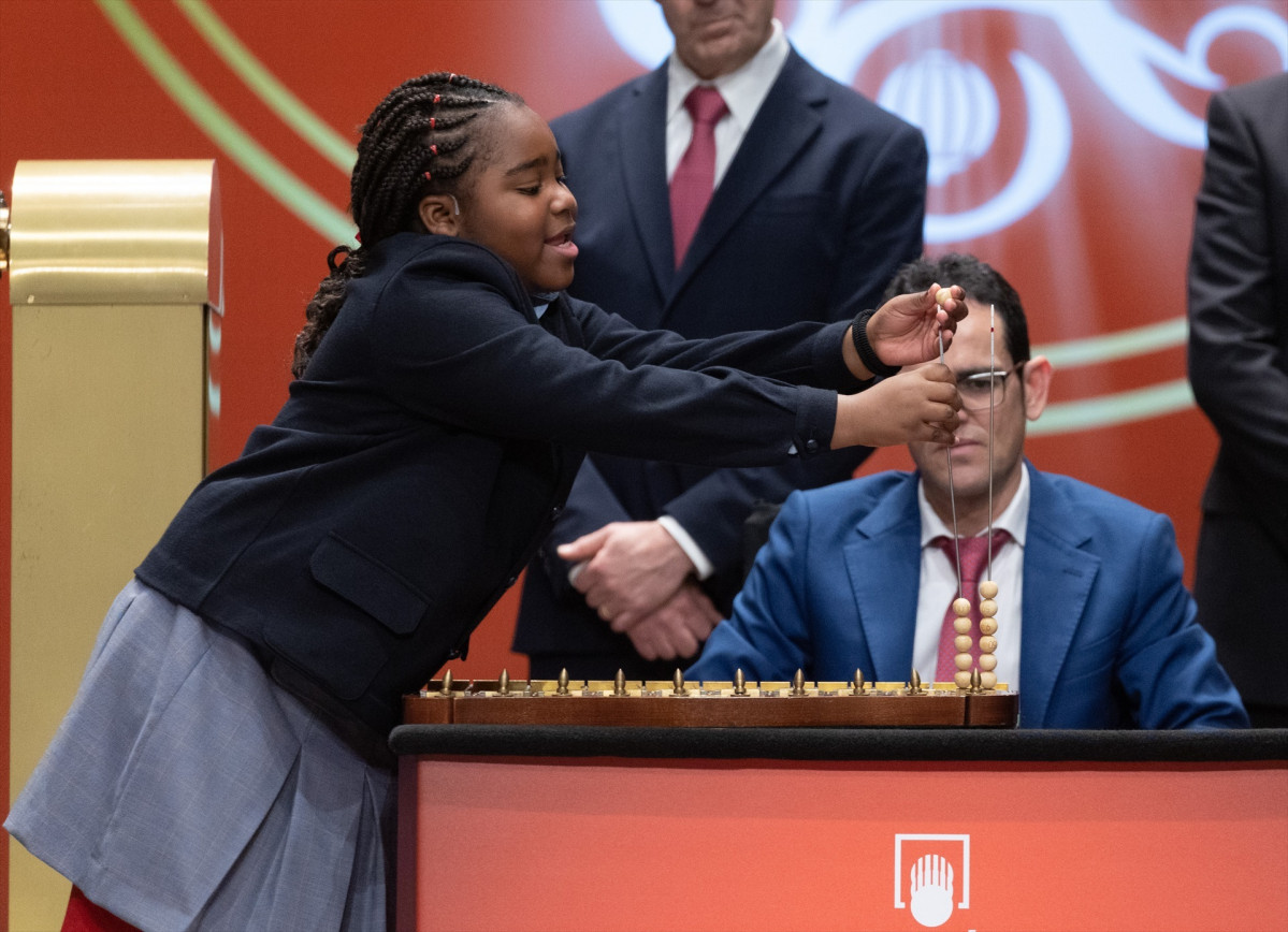 Una niu00f1a de la residencia de San Ildefonso canta la cantidad de dinero de uno de los premios del Sorteo Extraordinario de la Loteru00eda de Navidad 2022 en una foto de Eduardo Parra