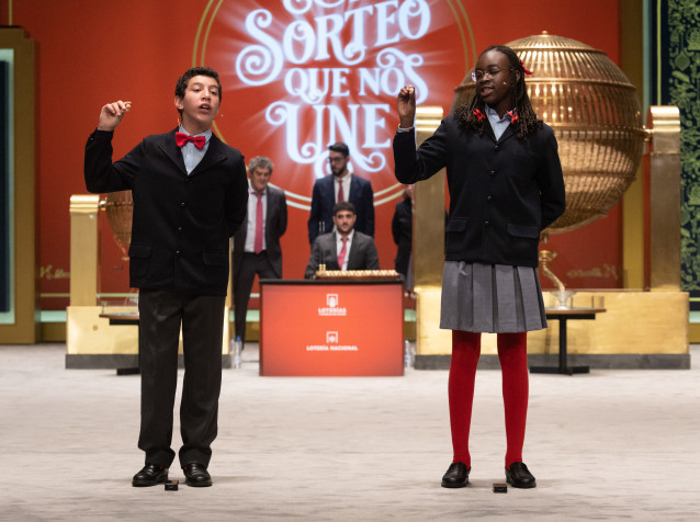 Dos niños de la residencia de San Ildefonso cantan un cuarto premio del Sorteo Extraordinario de la Lotería de Navidad 2022.