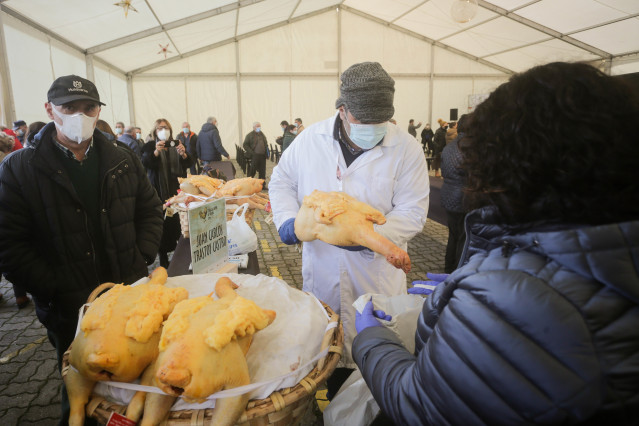 Archivo - Una mujer compra un capón en la Feria do Capón de Vilalba, a 21 de diciembre de 2021, en Vilalba, Lugo