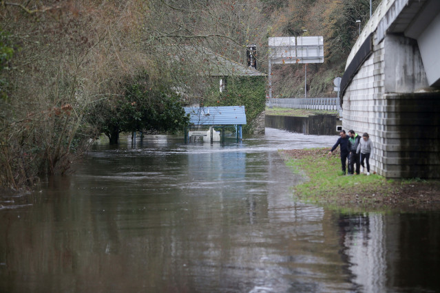 Varias personas observan la crecida del río Miño debido a las lluvias, en Lugo, a 25 de diciembre de 2022, en Lugo, Galicia, (España). La crecida del Miño se debe a que las precipitaciones acumuladas entre el día 23 y hoy sobrepasan los 70  litros por met
