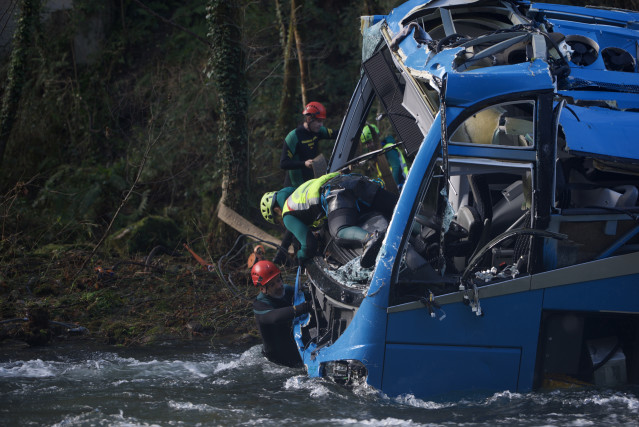 Varios efectivos del Grupo Especial de Actividades Subacuáticas de la Guardia Civil (GEAS) participan en la labor de izado del autobús accidentado.