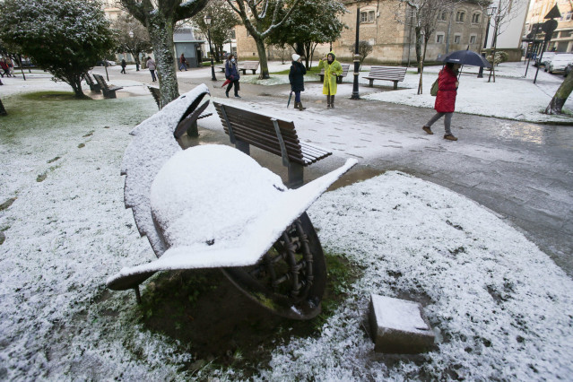 Varias personas pasean por una calle nevada, a 18 de enero de 2023, en Lugo, Galicia (España).