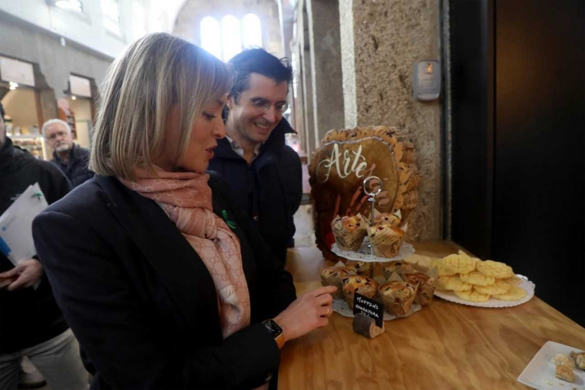 La conselleira de Política Social e Xuventude, Fabiola García, visita la tienda Raíña Paraíso en la plaza de Abastos de Santiago, uno de los establecimientos adheridos al programa para fomentar u
