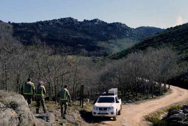 Trabajadores forestales observan el incendio forestal en el pueblo de Salgueiros, a 7 de febrero de 2023, en Muíños, Ourense, Galicia (España). La Consellería de Medio Rural de Galicia ha informado de un incendio forestal activo, originado en Portugal, qu