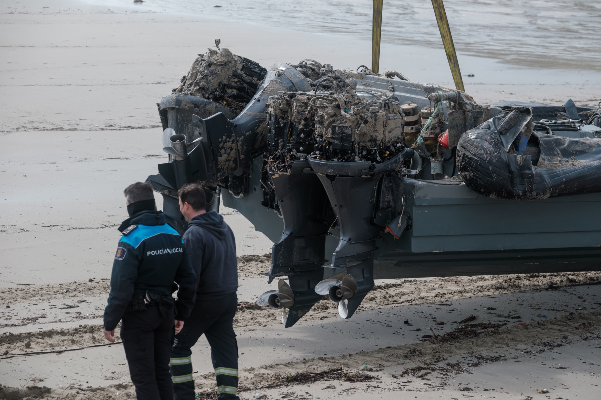Archivo - Un policía junto a la planeadora varada en la playa de Nemiña, a 24 de marzo de 2023, en Muxía, A Coruña