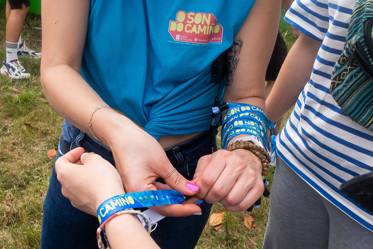 Archivo - Una chica pone una pulsera en la zona de acampada en el festival Oson de Camiño, en el Monte do Gozo, a 15 de junio de 2022, en Santiago de Compostela