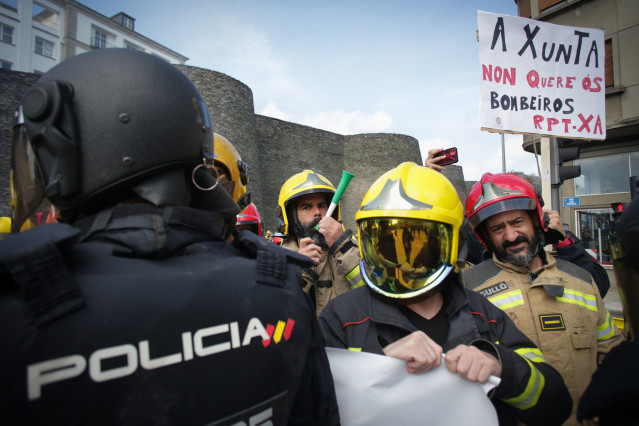 Antidisturbios de la Policía durante la protesta de bomberos de consorcios provinciales al intentar colocar una pancarta ante la sede de la Xunta, a 23 de mayo de 2023, en Lugo, Galicia (España). Los bomberos de consorcios provinciales se manifiestan en L