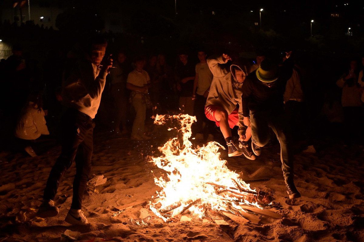 Archivo - Varios jóvenes saltan una hoguera en la noche de San Juan, en A Coruña