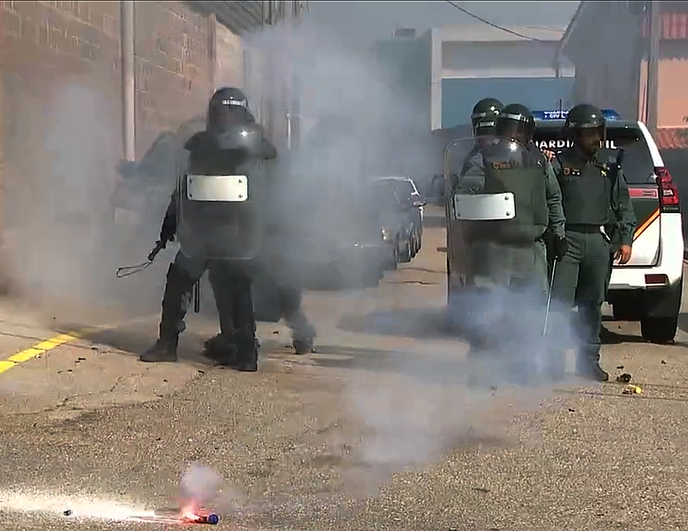 Agentes de la Guardia Civil se protegen del lanzamiento de objetos durante la huelga del metal en Vigo en una imagen de la CRTVG