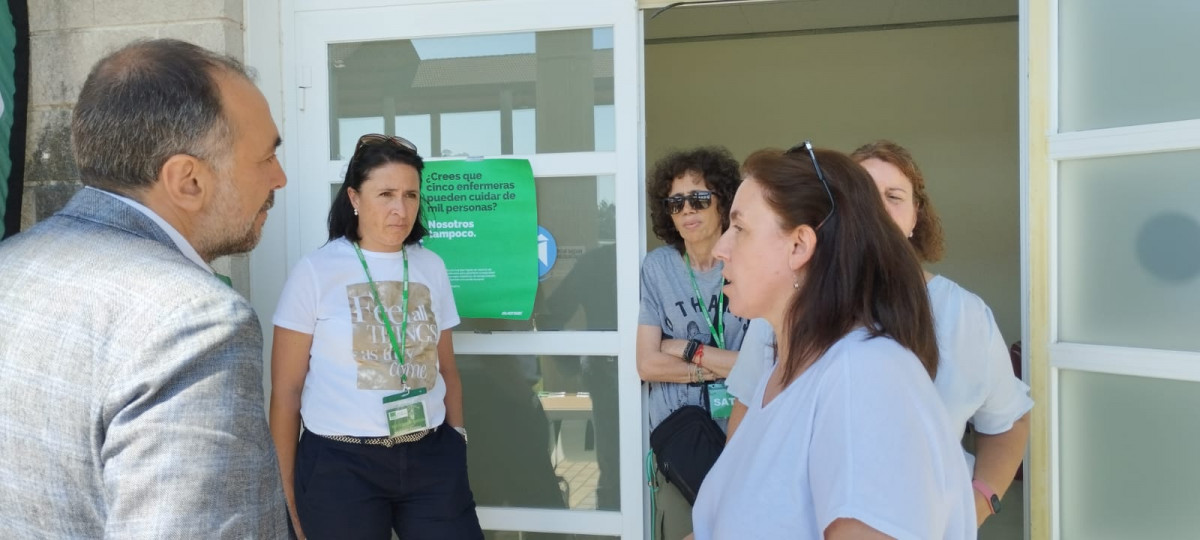 El Conselleiro de Sanidade, Julio Garcu00eda Comesau00f1a, conversa con las integrantes del Sindicato Satse en la entrada del recinto ferial de Silleda
