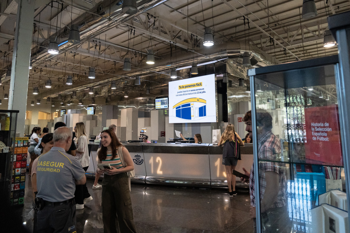 Varias personas en una oficina de correos, a 13 de julio de 2023, en Madrid.