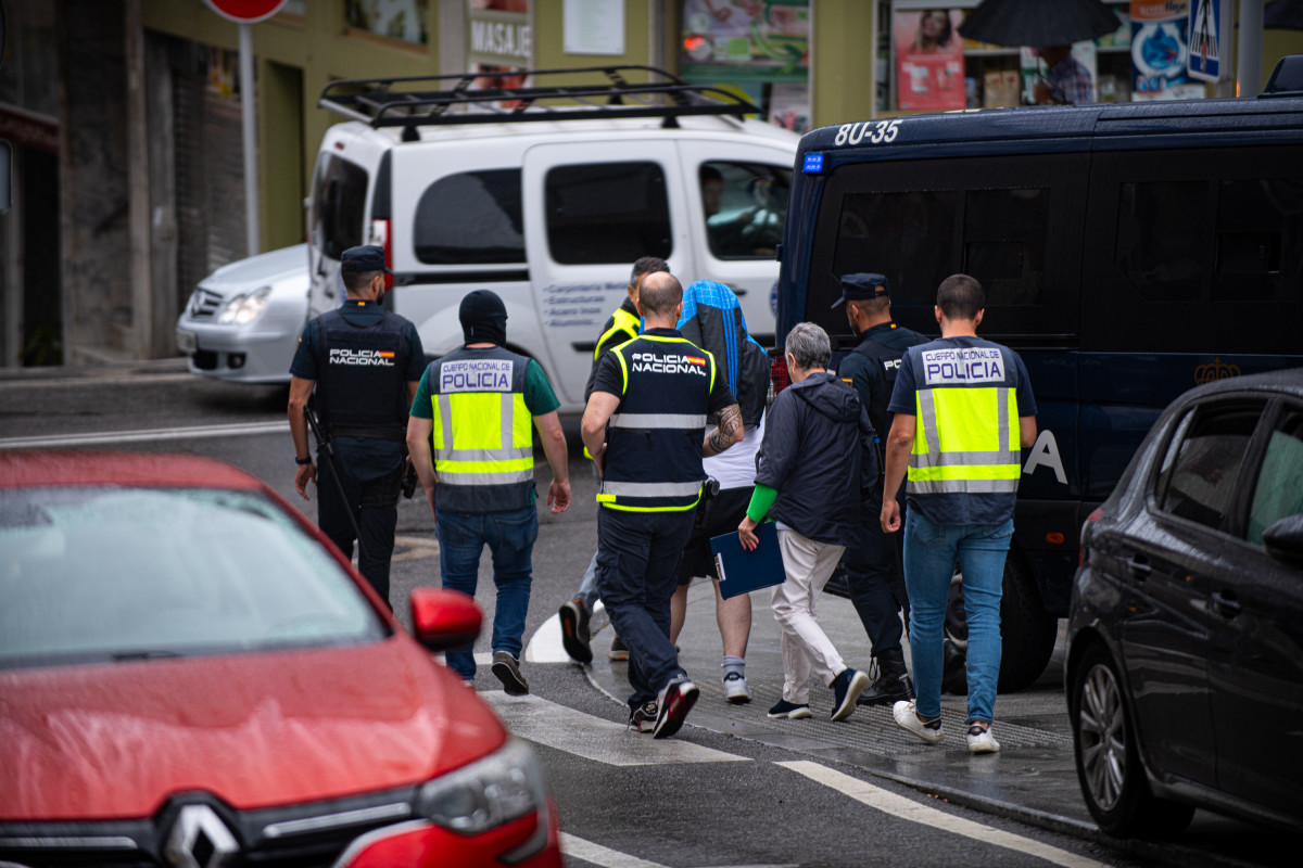 Agentes de policía trasladan a un detenido durante un operativo policial en Rúa do Progreso, a 1 de agosto de 2023, en Sanxenxo.