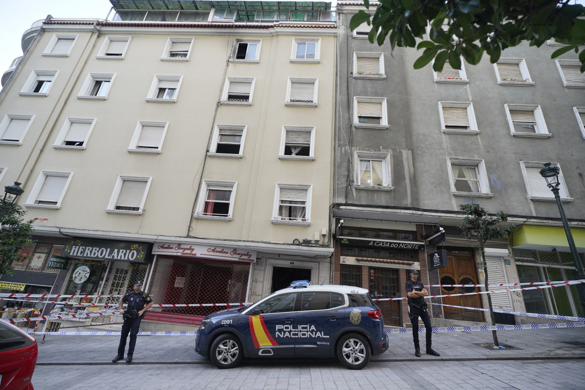 Un vehículo y dos agentes de Policía Nacional frente al edificio donde se ha producido un incendio en la calle Alfonso X el Sabio de Vigo, a 11 de octubre de 2023, en Vigo, Pontevedra, Galicia (Espa