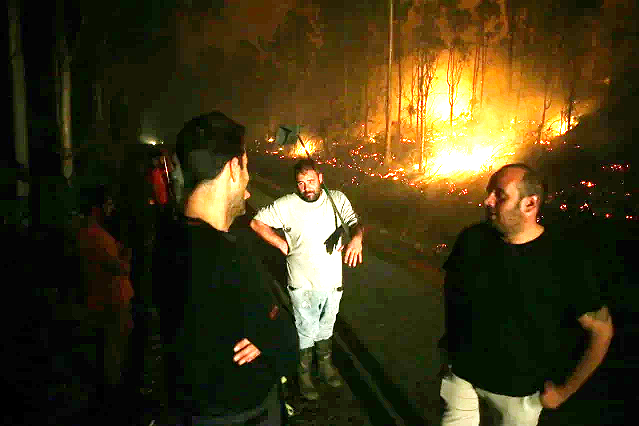 Vecinos de Trabada ayunda a controlar el incendio forestal en una foto de EP