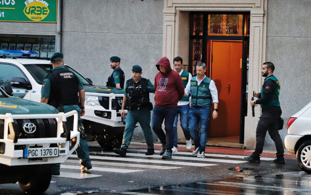 La Guardia Civil y el detenido salen de la vivienda que ha sido registrada, a 17 de octubre de 2023, en A Gándara, Narón, A Coruña, Galicia (España). Efectivos de la Guardia Civil de A Coruña se han desplazado hasta el domicilio del detenido por el crimen