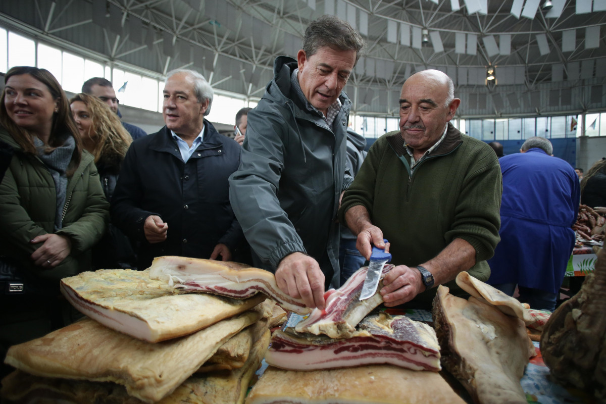 Un hombre corta paletas de jamón durante la celebración de la Feria de Santos de Monterroso, a 1 de noviembre de 2023, en Monterroso, Lugo
