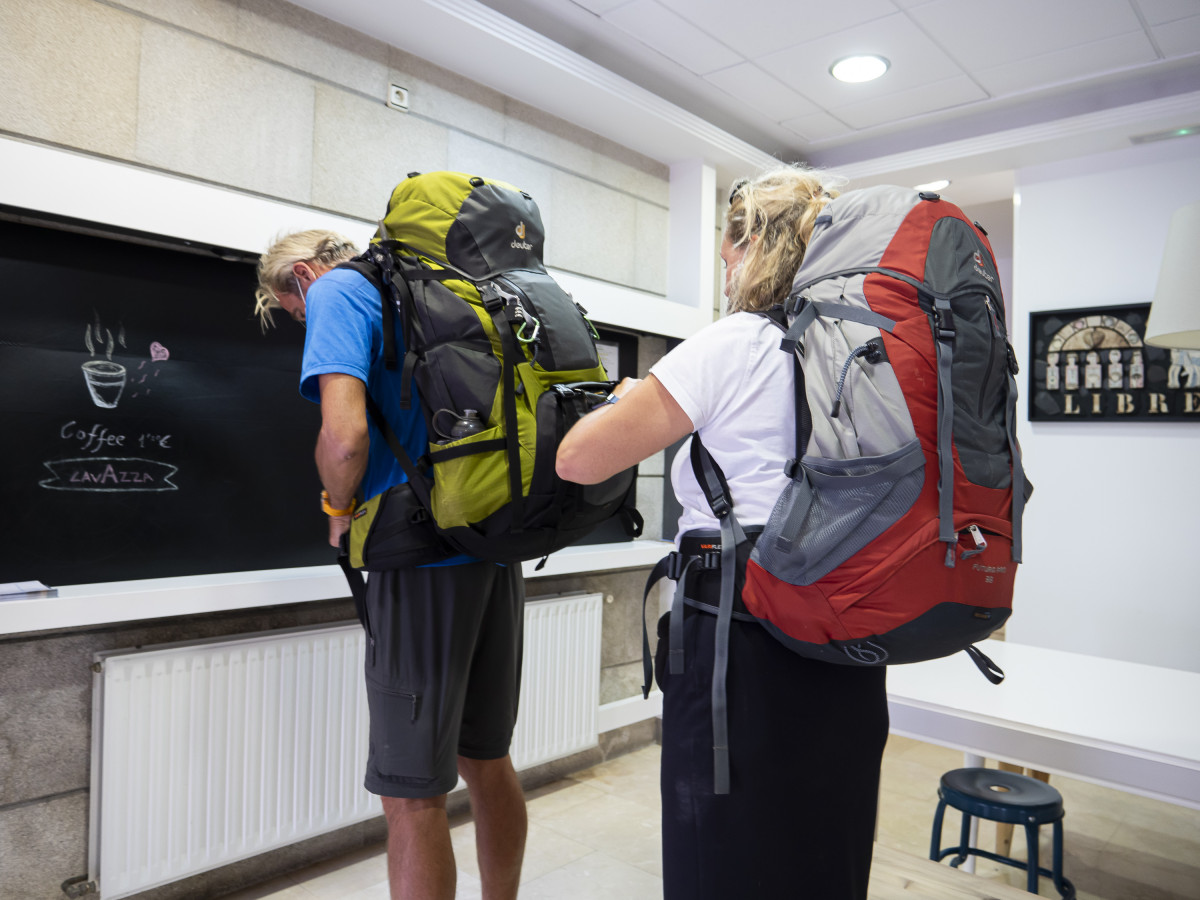 Archivo - Una peregrina busca su documentación en una mochila para acceder a un albergue, en Santiago de Compostela, a 9 de octubre de 2021, en Santiago de Compostela, A Coruña, Galicia (España). G