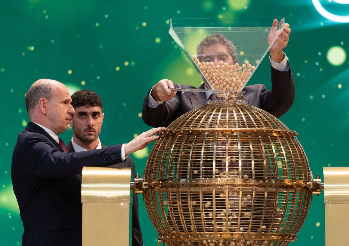 Varios hombres preparan el bombo para el Sorteo Extraordinario de la Lotería de Navidad 2023 en el Teatro Real de Madrid, a 22 de diciembre de 2023, en Madrid (España). Hoy se celebra el Sorteo Extr