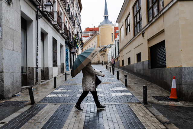 Archivo - Una mujer se protege de la lluvia con un paraguas, a 2 de noviembre de 2023, en Madrid (España). La Agencia Estatal de Meteorología (AEMET) ha activado la alerta roja en Madrid por fuertes vientos provocados por la borrasca Ciarán. En la mañana