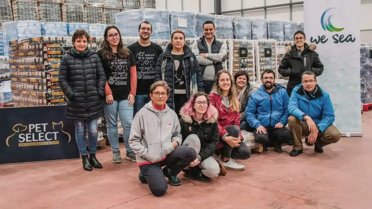 Socios de protectoras de animales recibiendo comida donada por Pet Select en una foto de Jealsa