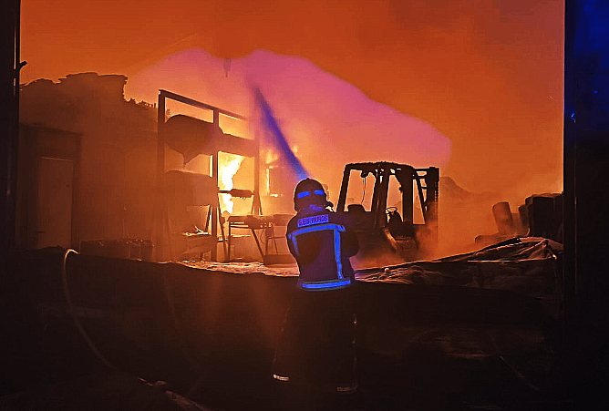 Bombero combate el fuego en el amacen de Cun de Mazaricos en una foto del Facebook del GES de Muros