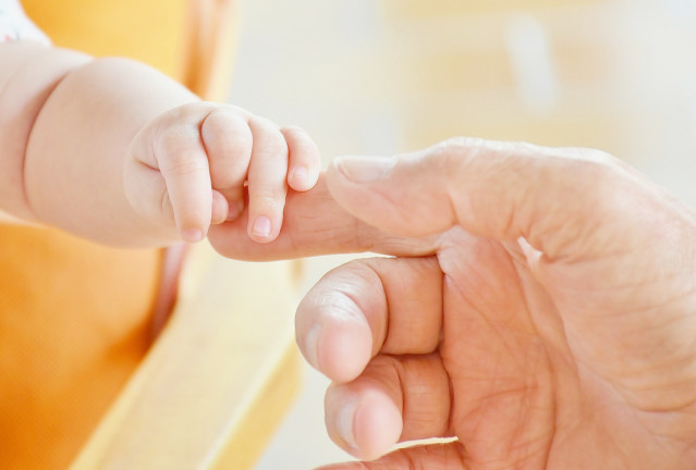 Imagen de una mano de un bebé y su madre.
