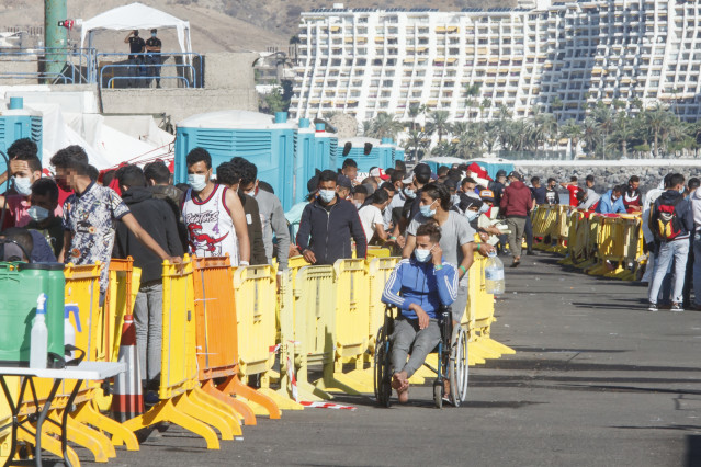 Archivo - Varios inmigrantes hacen cola en el Muelle de Arguineguín, en Gran Canaria