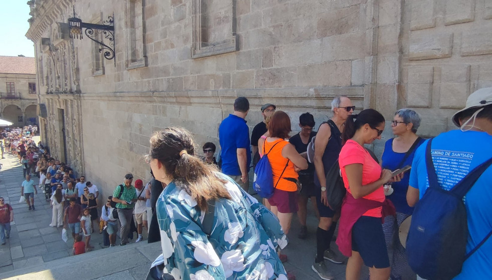 Centenares de peregrinos y turistas en la larga cola que atraviesa la escalinata de la Praza de la Quintana ayer para entrar a la Catedral