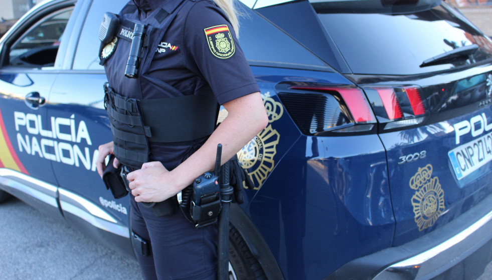 Un agente y un vehículo de la Policía Nacional