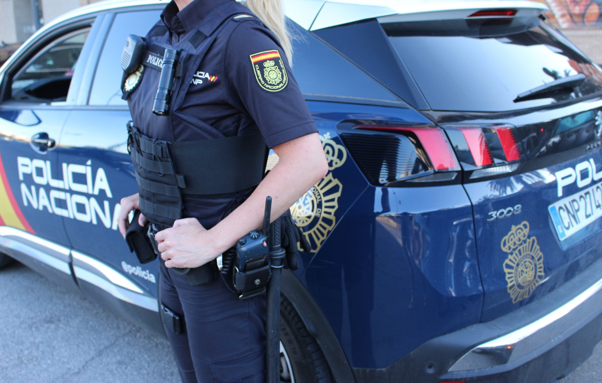 Un agente y un vehículo de la Policía Nacional