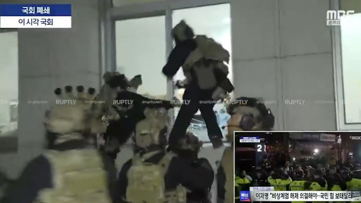 Militares entrando por la ventana en el edificio del Parlamento de Corea en una imagen de una televisión coreana