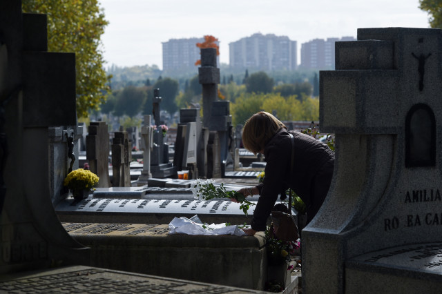 Archivo - Una mujer lleva flores a un ser querido, en el Cementerio de la Almudena, a 1 de noviembre de 2024, en Madrid (España). Este año, los cementerios de Madrid han ampliado su horario y han reforzado su servicio de limpieza, jardinería y vigilancia