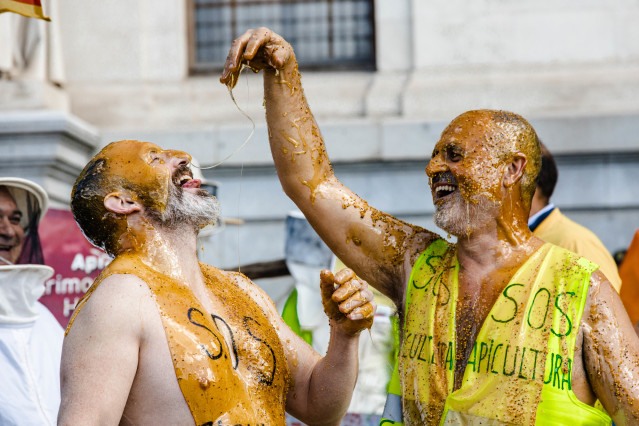 Archivo - Dos apicultores bañados en miel durante una concentración de las organizaciones profesionales agrarias y entidades relacionadas con el sector apícola frente al Ministerio de Agricultura, a 9 de marzo de 2023, en Madrid (España). El sector apícol