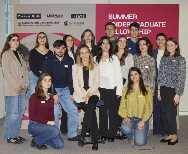 La directora de la Fundación Barrié, Carmen Arias, junto a los 14 becarios del programa