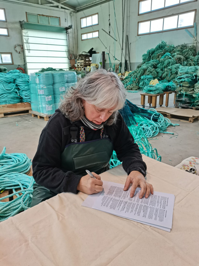 La presidenta de la Federación Galega de Redeiras Artesás O Peirao, María Jesús González, firma la alianza de rederas del norte
