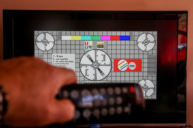 Archivo - Una persona utiliza su mando de la televisión para buscar canales, en Madrid (España), a 7 de octubre de 2020. El cese de emisiones de algunos canales en sus antiguas frecuencias de la TDT en la Comunidad de Madrid se producirá este miércoles, s