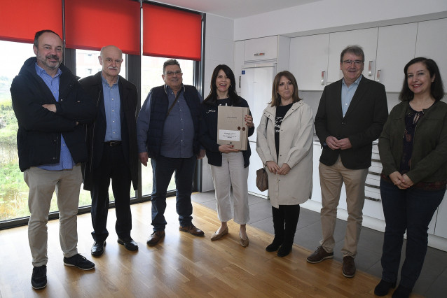 La conselleira de Vivenda e Planificación de Infraestruturas, María Martínez Allegue, entre a dos de los adjudicatarios las llaves de su nueva vivienda.