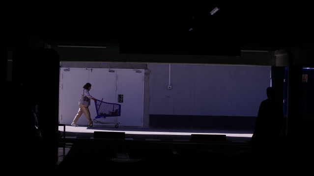 Una mujer sale del supermercado en A Coruña durante el apagón, a 28 de abril de 2025, en A Coruña, Galicia.