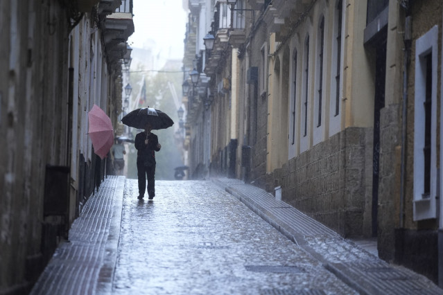 Archivo - Transeuntes bajo sus paraguas durante la intensa lluvia. A 11 de octubre de 2024, en Cádiz (Andalucía, España). La Agencia Estatal de Meteorología (Aemet) ha activado para este viernes avisos de nivel naranja por lluvia y amarillo por tormenta e