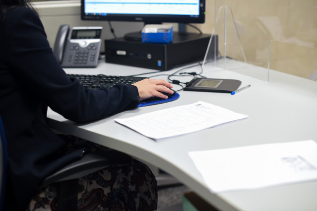 Archivo - Una empleada pública atiende a una contribuyente en la oficina de la Agencia Estatal de la Administración Tributaria, el día que el Gobierno ha propuesto subir el salario de los empleados públicos un 2% para 2022, a 5 de octubre de 2021, en Madr