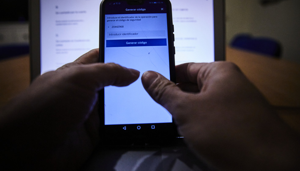 Archivo - Una persona con el móvil y el ordenador encendidos, en Madrid (España), a 9 de febrero de 2021.  Este martes 9 de febrero se celebra el Día de la Internet Segura, que en esta edición est