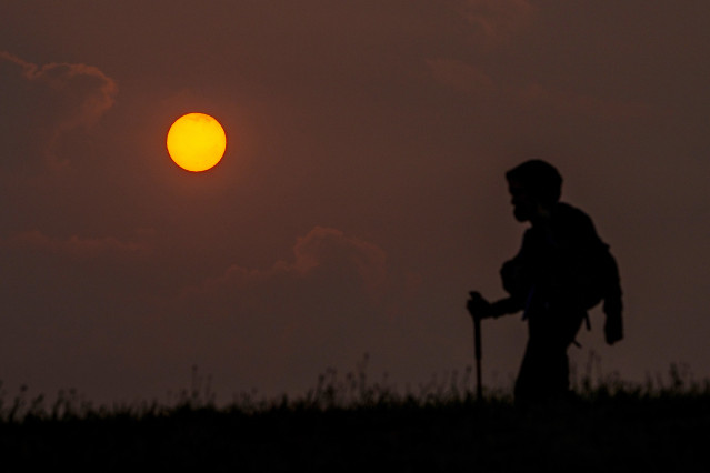 Archivo - Un peregrino camina durante la salida del sol en el Monte do Gozo, a 19 de septiembre de 2024, en Santiago de Compostela, A Coruña, Galicia (España). Los incendios que afectan a Portugal han dejado en Galicia y parte del norte de España un espes