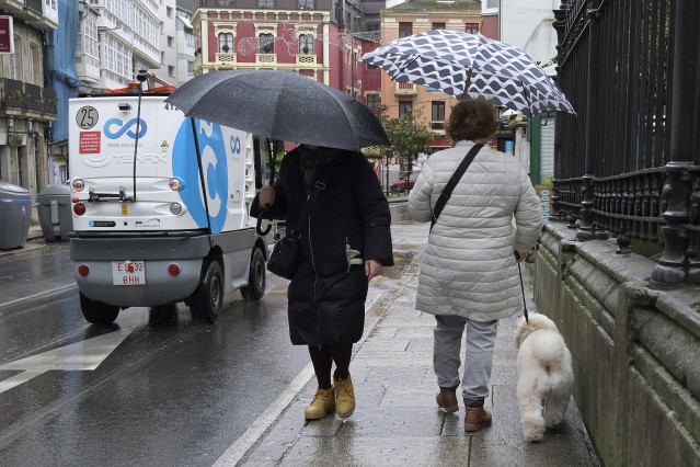 Archivo - Dos personas se refugian del viento con paraguas, a 8 de febrero de 2024, en A Coruña, Galicia (España). El paso de la borrasca Karlotta por Galicia está provocando a lo largo del día de hoy incidencias, lluvias copiosas y vientos de mucha inten