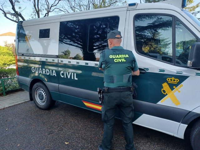 Imagen de una furgoneta y un agente de la Guardia Civil.