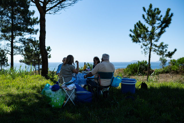 Archivo - Varias personas comen a la sombra de un árbol, a 30 de septiembre de 2023, en Sanxenxo, Pontevedra, Galicia (España).