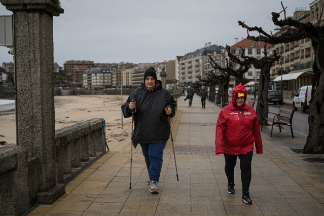 Archivo - Dos personas en el paseo marítimo de una playa de la comarca de Salnés, a 27 de enero de 2025, en Salnés, Pontevedra, Galicia (España). La borrasca 'Herminia' recorre la Península hoy y llegará hasta el Mediterráneo y Baleares al final del día c