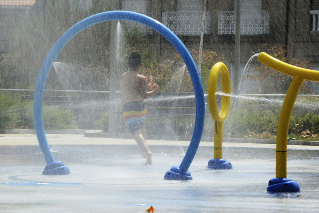 Archivo - Una mujer se refresca en unos chorros de un parque durante un día de la segunda ola de calor de verano en España, a 14 de julio de 2022, en xxx, Ourense, Galicia (España). La Dirección Xeral de Emerxencias e Interior de la Xunta ha activado para