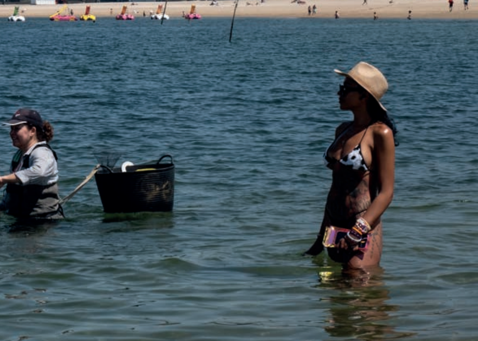 Mariscadora y turista comparten playa en Vilagarcu00eda en la Ru00eda de Arousa en una foto de Pedro Armestre para Greenpeace